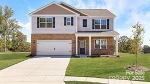 view of front of home featuring concrete driveway, a front yard, a garage, and a porch