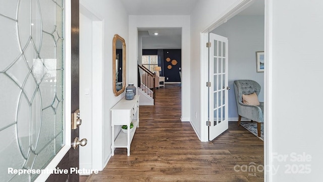 foyer entrance featuring french doors, wood finished floors, baseboards, and stairs