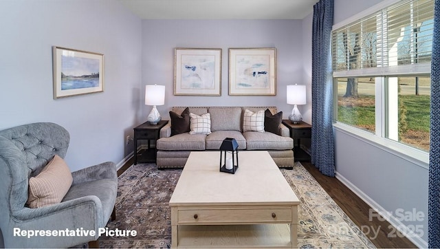 living room with healthy amount of natural light, dark wood-style flooring, and baseboards