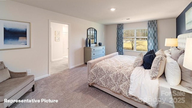 bedroom with carpet flooring, baseboards, and connected bathroom