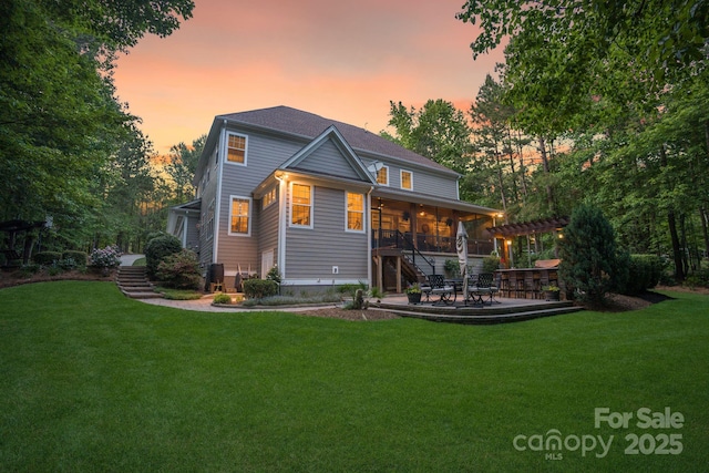 rear view of property with stairway, a lawn, ceiling fan, and a patio area
