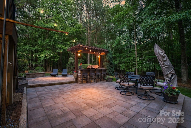 view of patio / terrace featuring a pergola, a view of trees, outdoor dry bar, and a deck