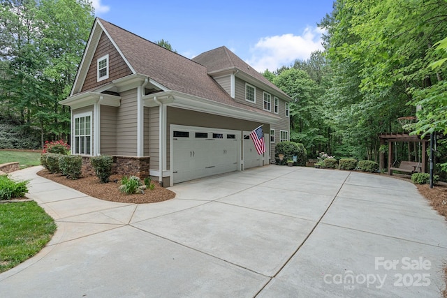 view of home's exterior featuring a garage, a shingled roof, and concrete driveway