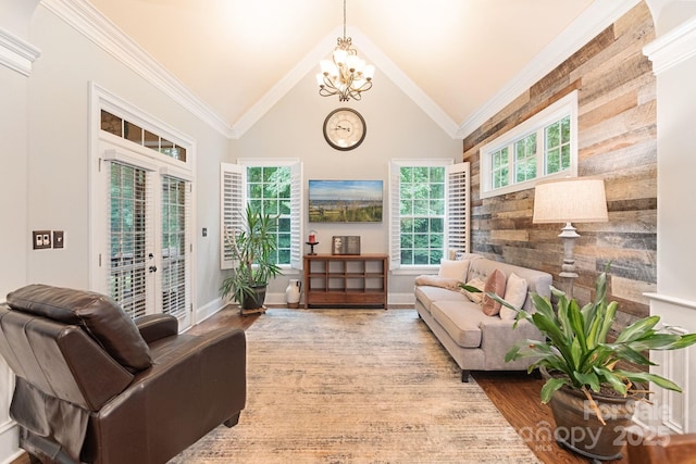 interior space featuring an inviting chandelier, ornamental molding, wood finished floors, wooden walls, and vaulted ceiling