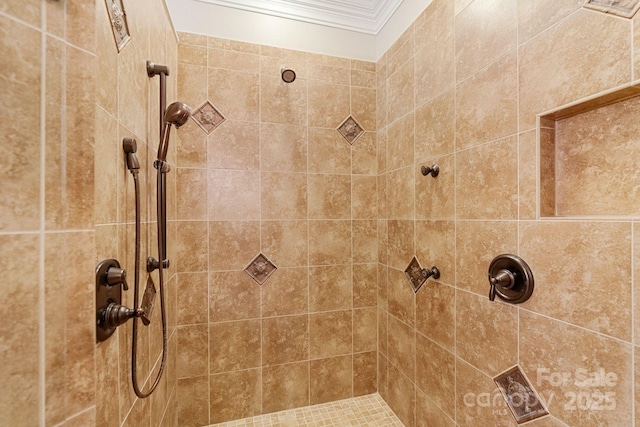 bathroom with ornamental molding and a tile shower