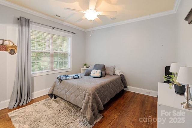 bedroom with baseboards, ornamental molding, wood finished floors, and visible vents