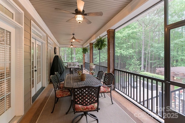 sunroom featuring french doors, a ceiling fan, and outdoor dining area