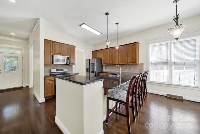 1855 Second Baxter Xing, Fort Mill, SC 29708 - kitchen with stainless steel appliances, brown cabinets, a sink, and dark wood-style flooring
