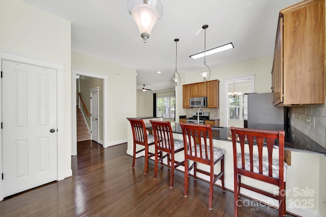 1855 Second Baxter Xing, Fort Mill, SC 29708 - kitchen featuring stainless steel appliances, backsplash, dark wood-style flooring, brown cabinetry, and dark countertops
