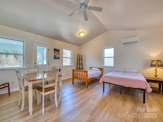 bedroom with vaulted ceiling, light wood-style flooring, and a wall mounted AC