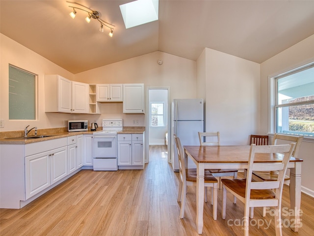 kitchen with white appliances, a healthy amount of sunlight, open shelves, and a sink
