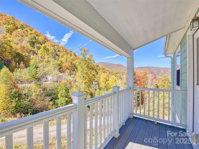 wooden terrace featuring a forest view
