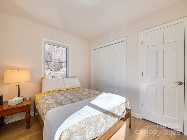 bedroom featuring light wood finished floors, a closet, and baseboards
