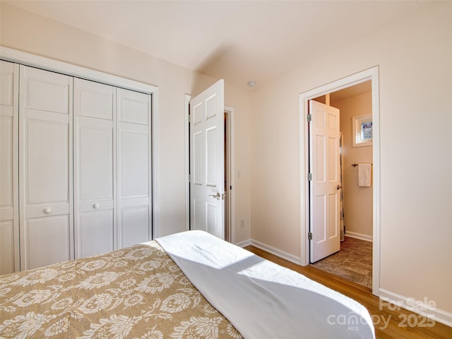 bedroom featuring light wood finished floors, a closet, and baseboards