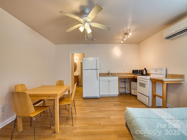 kitchen with light wood finished floors, a wall unit AC, a sink, white appliances, and light countertops
