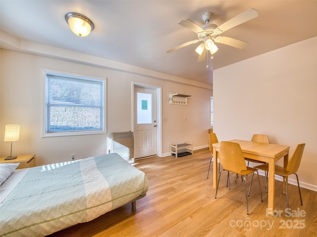 bedroom with ceiling fan, baseboards, and light wood-style floors
