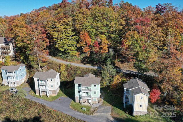 birds eye view of property featuring a wooded view and a residential view