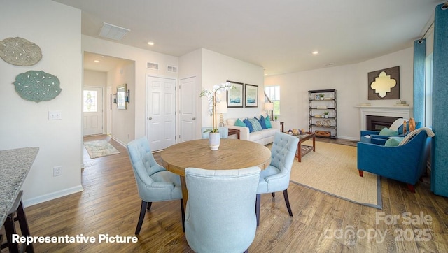 129 Way Cross Ln, Troutman, NC 28166 - dining space with wood finished floors, healthy amount of natural light, recessed lighting, and a glass covered fireplace