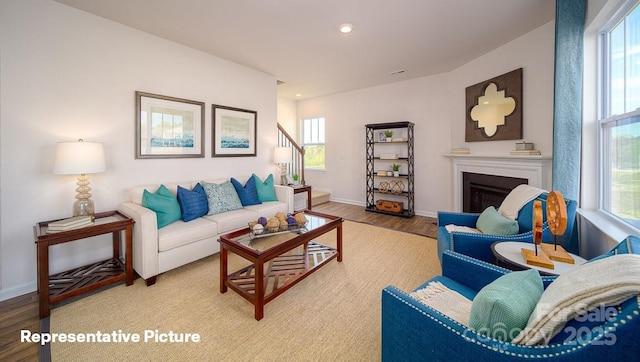 129 Way Cross Ln, Troutman, NC 28166 - living room with plenty of natural light, wood finished floors, a fireplace, stairway, and recessed lighting