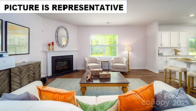 living area featuring baseboards, a fireplace with flush hearth, dark wood finished floors, and visible vents