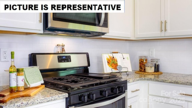 kitchen with white cabinets, backsplash, stainless steel appliances, and light stone countertops