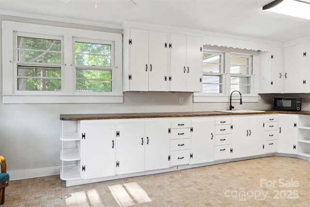 130 Casper Rd, Gold Hill, NC 28071 - kitchen with white cabinets, open shelves, black microwave, a sink, and baseboards