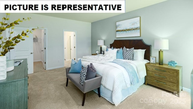 carpeted bedroom featuring baseboards and a walk in closet