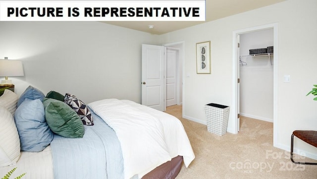 bedroom featuring light colored carpet, a spacious closet, baseboards, and a closet