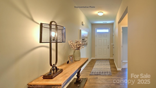 entryway featuring baseboards and wood finished floors