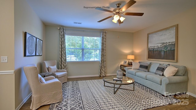 living area featuring a ceiling fan, baseboards, visible vents, and wood finished floors