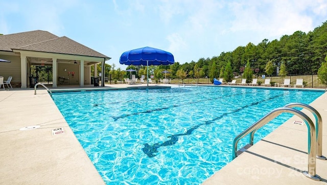 community pool with fence and a patio area