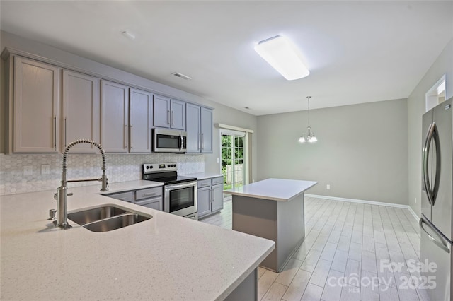 9321 Bradstreet Commons Way, Charlotte, NC 28215 - kitchen featuring stainless steel appliances, a sink, decorative backsplash, a kitchen island, and gray cabinets