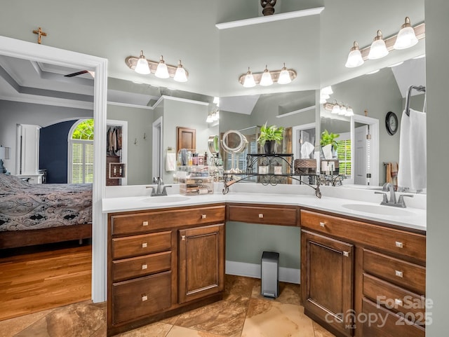 bathroom with crown molding, double vanity, and a sink
