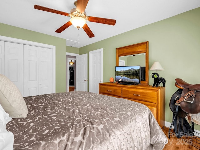 bedroom featuring a closet, a ceiling fan, baseboards, and wood finished floors