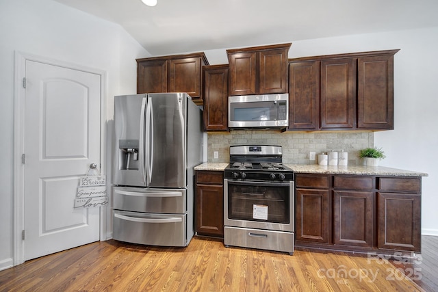 9029 Woodview Ct, Fort Mill, SC 29707 - kitchen with appliances with stainless steel finishes, dark brown cabinets, light wood-type flooring, and decorative backsplash