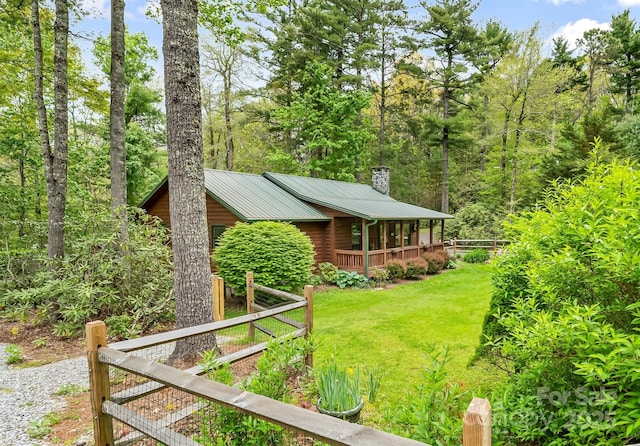 6562 Gingercake Rd, Newland, NC 28657 - view of property exterior featuring a lawn, a chimney, metal roof, log siding, and covered porch