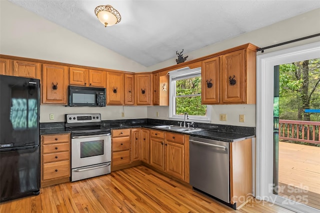 6562 Gingercake Rd, Newland, NC 28657 - kitchen featuring black appliances, a sink, lofted ceiling, light wood-style flooring, and brown cabinets