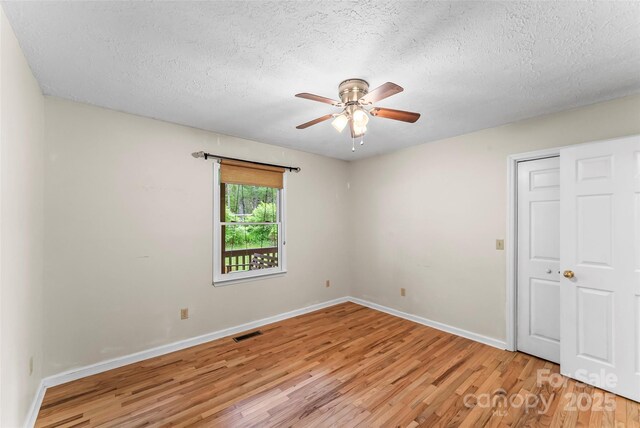 6562 Gingercake Rd, Newland, NC 28657 - unfurnished room featuring light wood-style floors, a ceiling fan, baseboards, and a textured ceiling