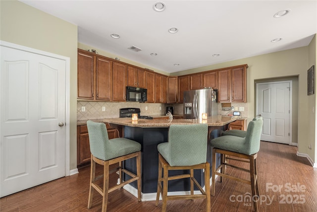 9159 Marasol Ln, Concord, NC 28027 - kitchen featuring black appliances, backsplash, dark wood finished floors, a kitchen bar, and recessed lighting