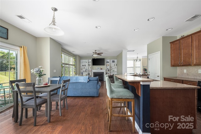9159 Marasol Ln, Concord, NC 28027 - kitchen with dark wood-style flooring, a ceiling fan, a fireplace, decorative light fixtures, and recessed lighting
