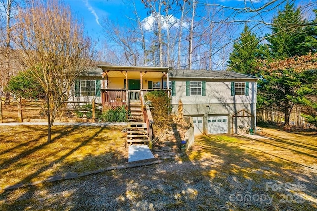 single story home featuring covered porch, an attached garage, stairs, and driveway