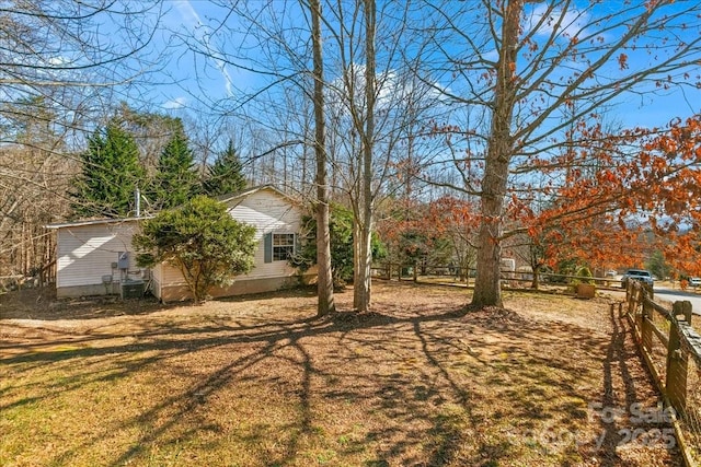 view of yard featuring central AC and fence