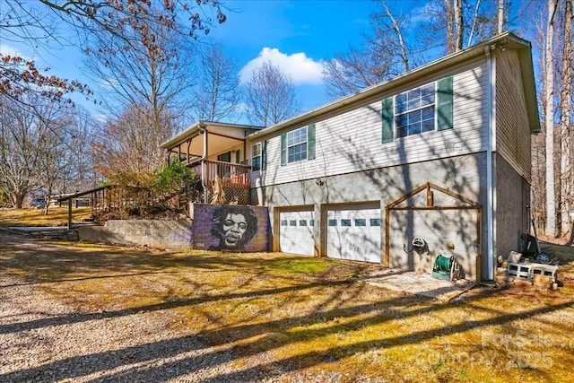 view of front facade featuring dirt driveway, an attached garage, and stucco siding