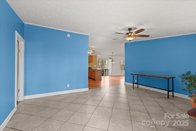 unfurnished living room with crown molding, baseboards, a ceiling fan, and a textured ceiling