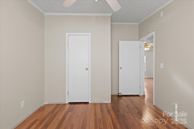 unfurnished bedroom featuring wood-type flooring, a textured ceiling, and crown molding