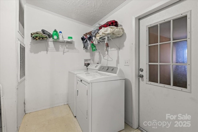 washroom with crown molding, laundry area, separate washer and dryer, a textured ceiling, and light floors