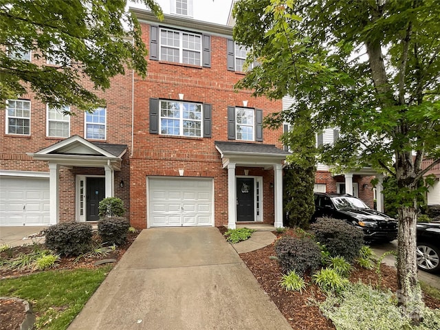 multi unit property featuring concrete driveway, a garage, and brick siding