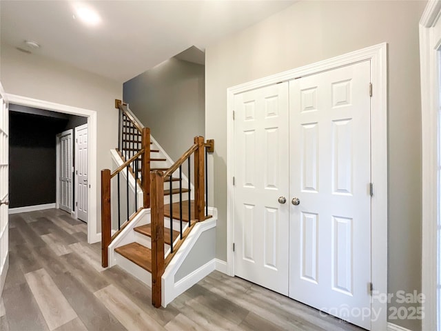 stairway with wood finished floors and baseboards