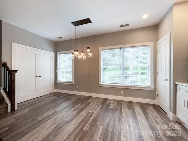 unfurnished dining area featuring dark wood-type flooring, plenty of natural light, baseboards, and recessed lighting