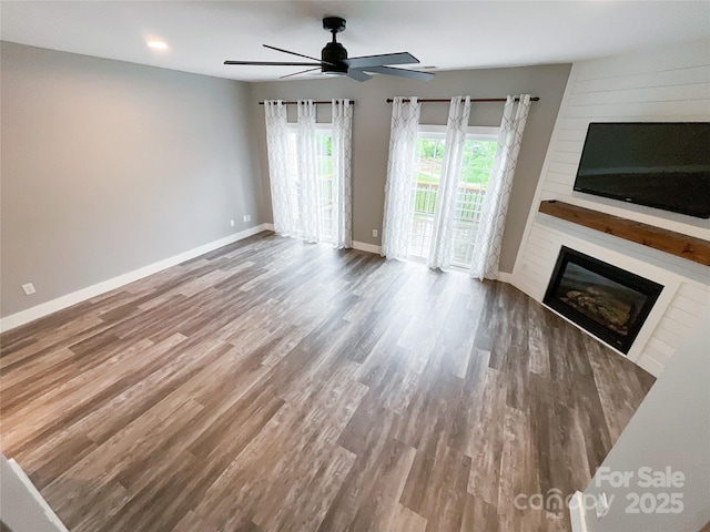 unfurnished living room featuring a fireplace, wood finished floors, a ceiling fan, baseboards, and recessed lighting